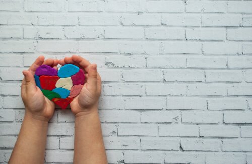 a plasticine heart in the hands of a child.