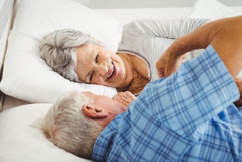 An elderly couple in bed.