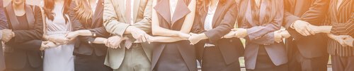 Coworkers holding hands representing holacracy.