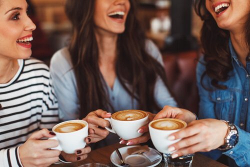 Happy friends undergoing a digital detox grabbing a cup of coffee together.