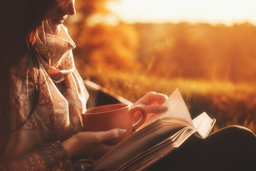 A woman reading biographies during sunset.