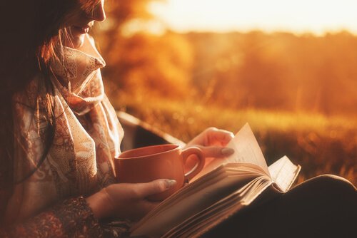 A woman reading biographies during sunset. 