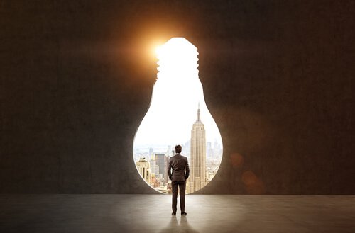 A guy looking out a lightbulb-shaped window.