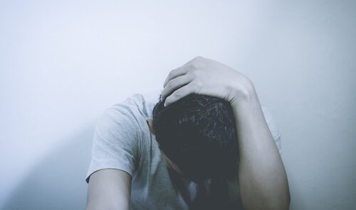 A worried man with his head down.