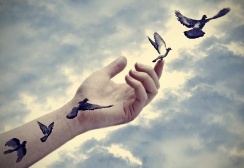 A hand with flying birds.