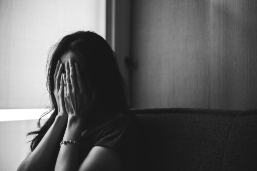 A woman with generalized anxiety disorder covering her face.