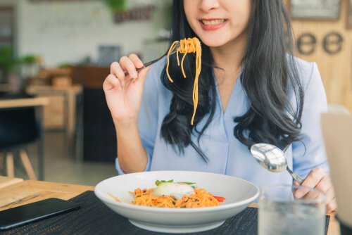 A woman eating pasta.