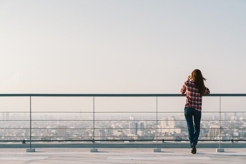 Woman looking out at the city and talking on the phone.