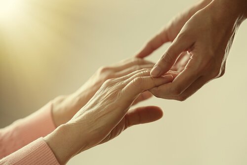 An old person holding a child's hands.