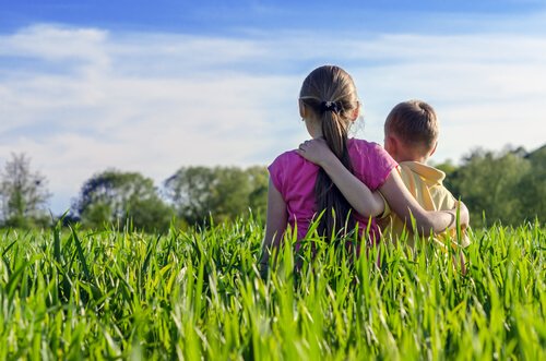 Siblings hugging from the back..