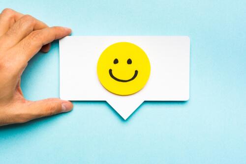 A business card with a smiley face on it, representing emotional branding.