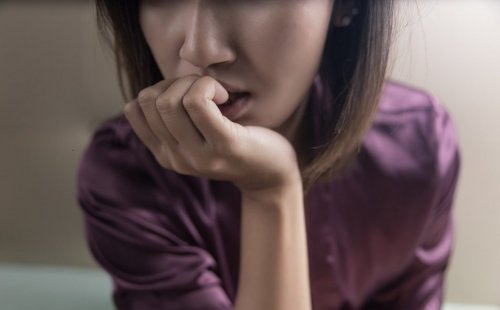 A woman biting her nails.