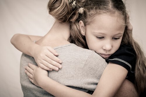 A woman hugging a little girl.