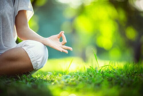 A woman doing decision-making with mindfulness in the grass.