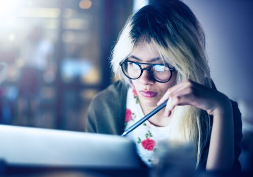 A woman working and studying at a computer.