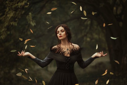 A woman with open arms creating a circle of leaves.