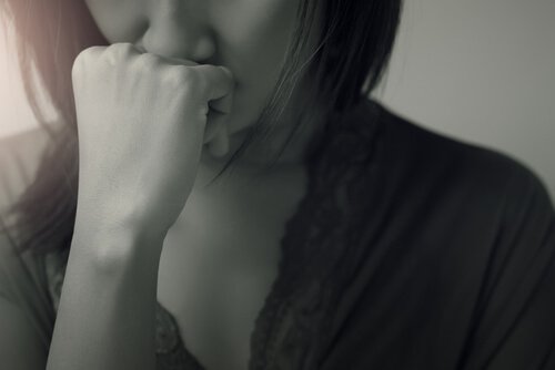 A woman with her hand on her mouth out of worry.