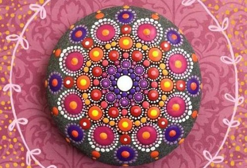 A colorful mandala painted on a rock.