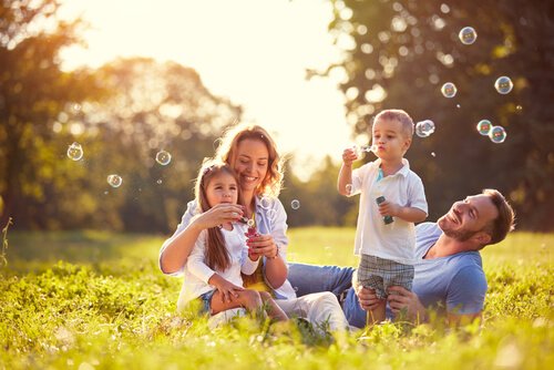 A family in the countryside blowing bubbles.