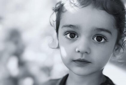 A little girl looking directly at the camera.