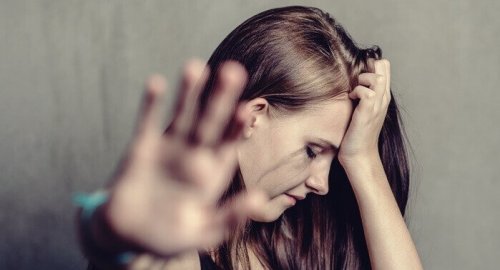 A seemingly upset woman motioning for someone to go away.