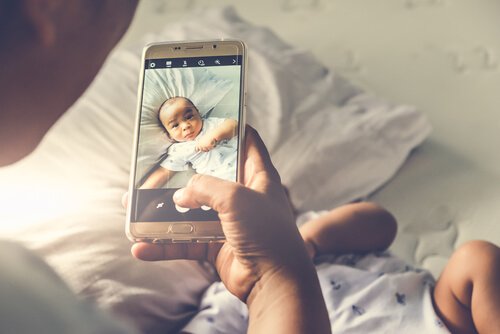 sharenting: a father taking a photo of his baby