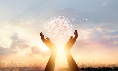 two hands holding an image of a brain in the sky