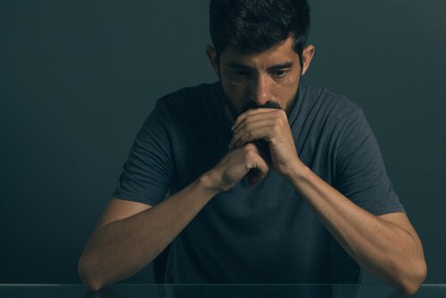 A man thinking and holding his hands.