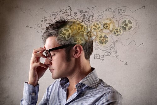 a man wearing glasses has his eyes closed with his hand on his face in thought, and an illustration of gears floating out of his mind