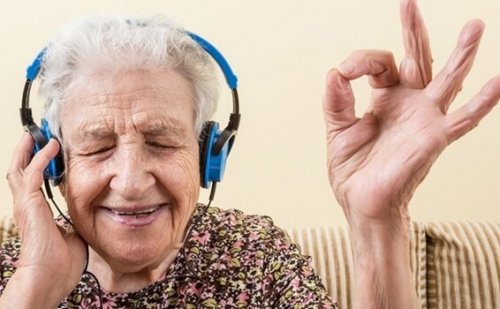 older woman listening to music with blue headphones