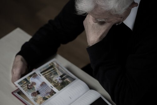 An older person looking at photographs.