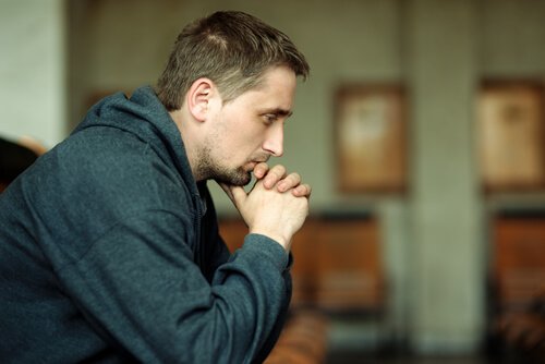 A prisoner sitting down thinking, representing the process of prisoner rehabilitation.