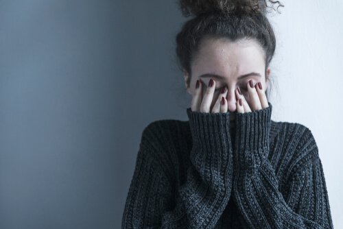 A frustrated woman covering her face representing destigmatizing mental illness