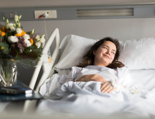 woman laying in a hospital bed thinking about the benefits of a positive attitude