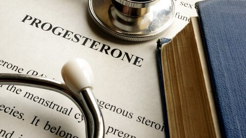 A close-up picture showing the word progesterone printed on a sheet of paper lying under a stethoscope.