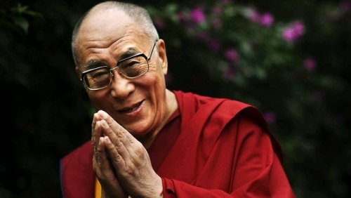The Dalai Lama with hands in prayer.