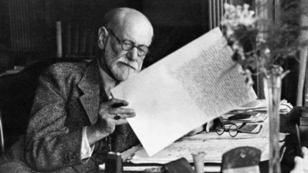 Sigmund Freud examining a paper.