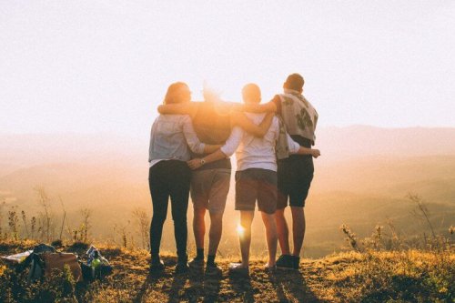 a group of people hugging each other on a mountain 