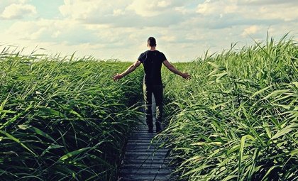 A man standing in a field learning to use the law of least effort.