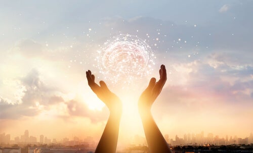 A pair of hands playing with a lit brain.