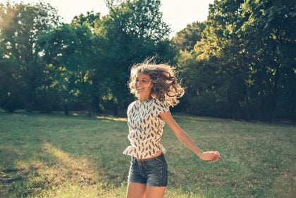 A happy woman in a field.