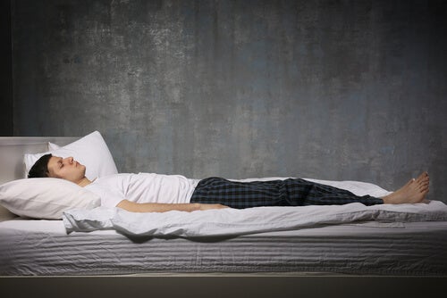 A man lying in bed, asleep, symbolizing how MR therapy can help with sleep paralysis.