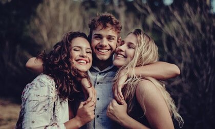 Three friends hugging.