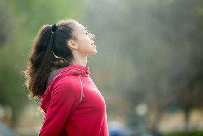 A woman outdoors stretching.