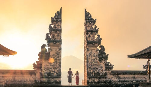 A couple at the gates of a Buddhist temple.