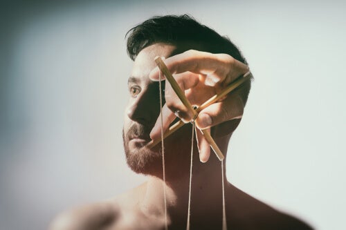 Marionette strings in front of a man's face, showing that brainwashing is real.