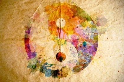 A colorful painting of yin and yang on brown paper.