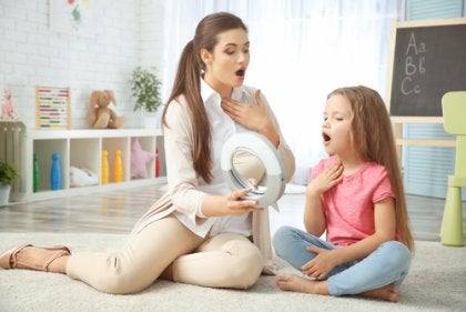 A speech therapist working with a little girl.
