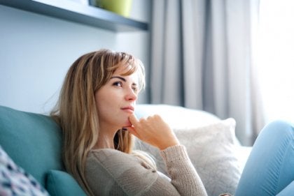 A woman sitting on the couch thinking.
