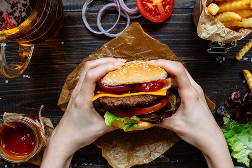 Iemand die op het punt staat junkfood te eten